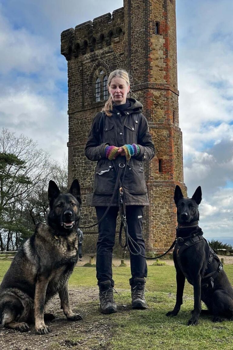 Photograph of Lisa from Nimbus Dogs with a Dutch Shepherd and a German Shepherd / Malinois